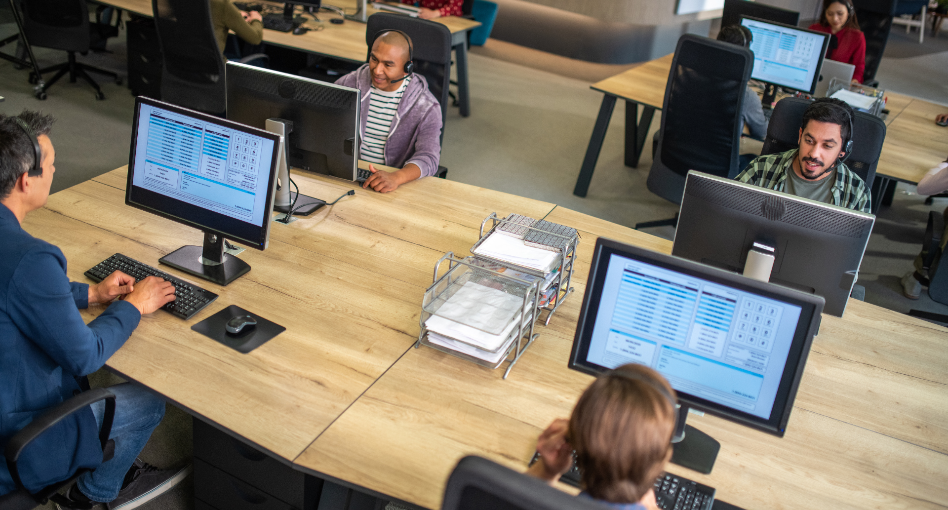 Team of IT professionals working at computers in an open office setting.